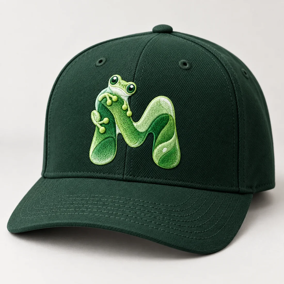 A dark green cap embroidered with the Maeish frog-and-M mark